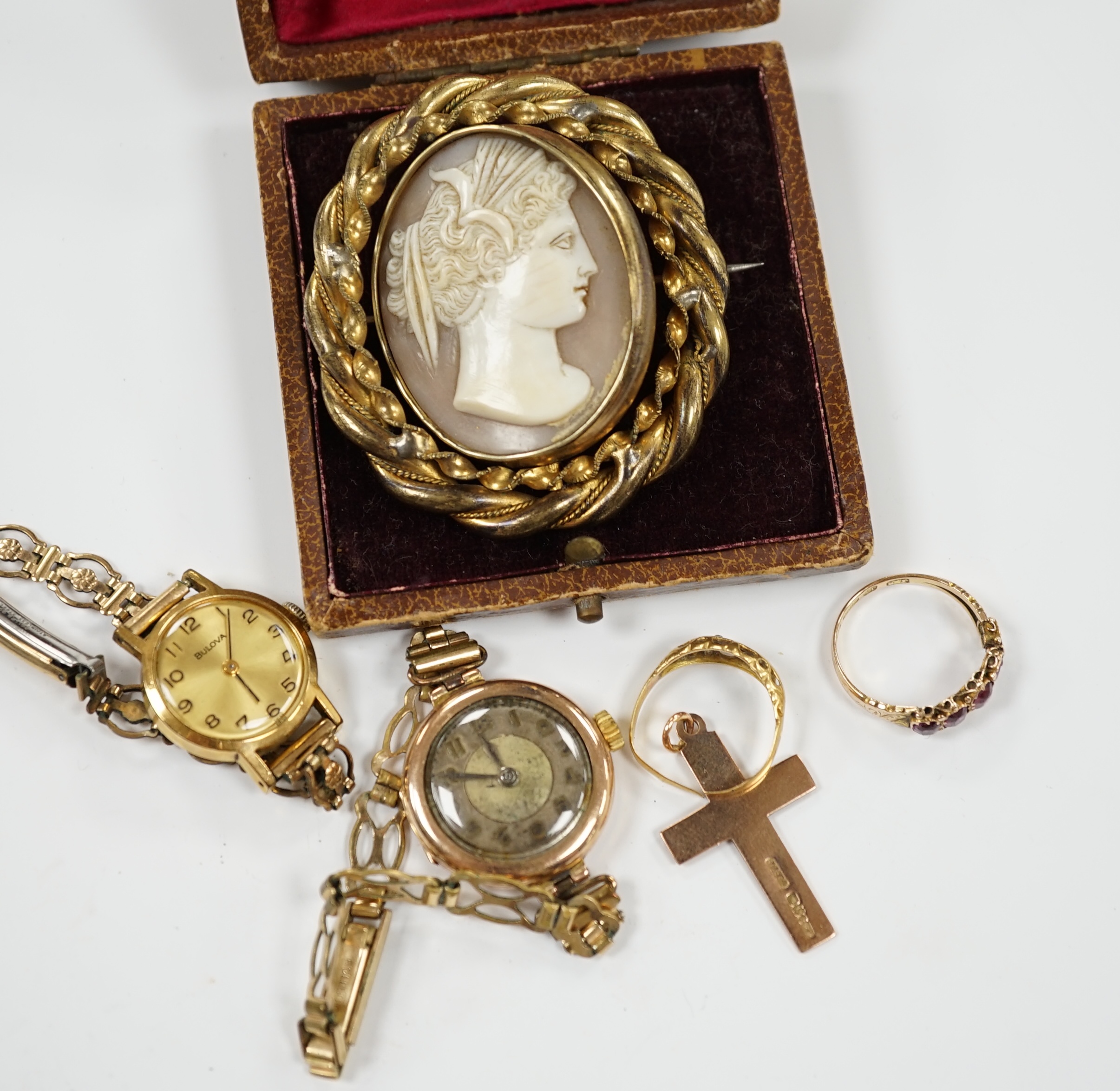 A Victorian 15ct gold and four (ex 5) stone garnet set half hoop ring, an 18ct gold ring, two lady's wrist watches including 9ct gold cased, a 9ct gold cross pendant and a gilt metal and cameo shell set brooch.